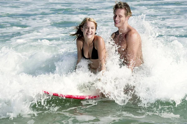 海で一緒にサーフィンをしているカップル — ストック写真