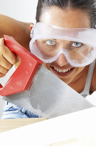 Primer Plano Una Mujer Con Gafas Aserrando Una Madera — Foto de Stock