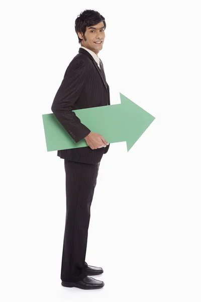 Empresário Segurando Uma Seta Verde Virada Para Esquerda — Fotografia de Stock