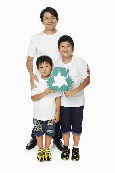 3つの笑顔の家族とリサイクルのロゴを保持 — ストック写真