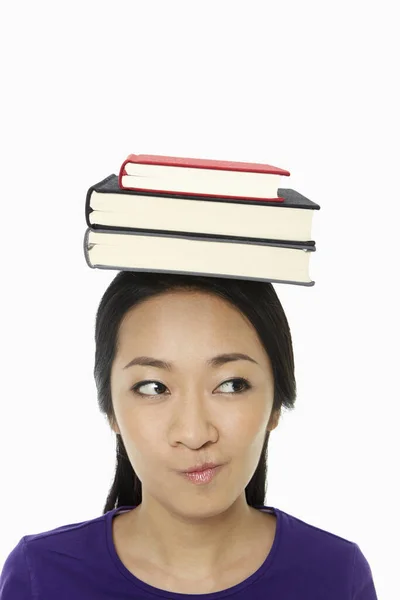 头上顶着一堆书的女人 — 图库照片