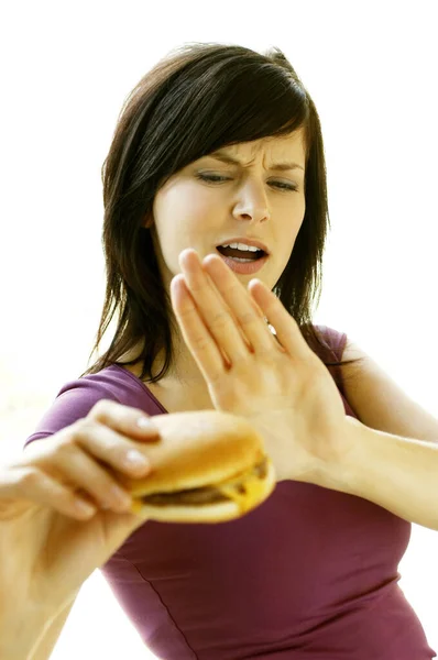 チーズバーガーを食べるのを控える女性 — ストック写真