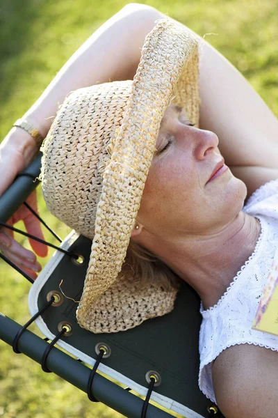 Hasır Şapkalı Bir Kadın Dinlenme Sandalyesinde Uyuyor — Stok fotoğraf