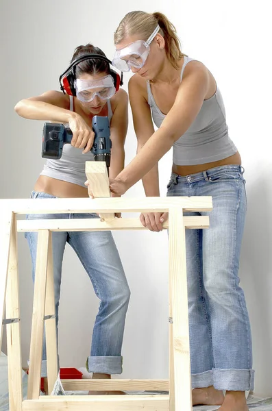 Una Mujer Ayudando Amiga Sostener Madera Mientras Perfora — Foto de Stock