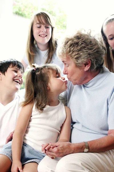 Girl Kissing Her Grandmother Whiles Her Brother Sisters Watching — Stock Photo, Image