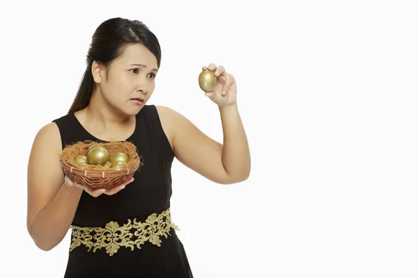 Mujer Mirando Huevo Dorado Con Curiosidad — Foto de Stock