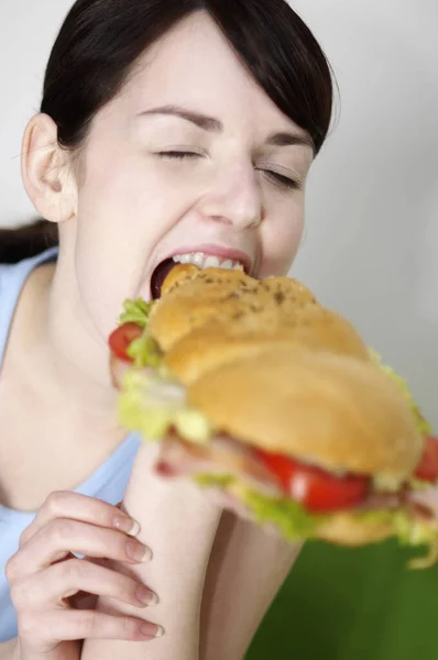 女人吃三明治和汉堡包 — 图库照片