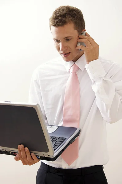 Hombre Con Corbata Rosa Sosteniendo Portátil Mano Mientras Habla Teléfono —  Fotos de Stock