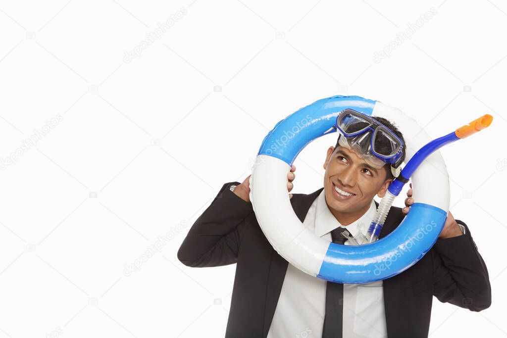 Businessman with swimming gear looking through a swimming tube