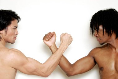 Üstsüz, kaslı, Afro-Amerikan bir adam ve bilek güreşi.