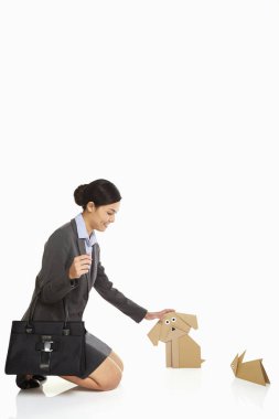 İş kadını kağıttan bir köpeği okşuyor