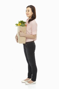 Cheerful woman with a bag of groceries clipart