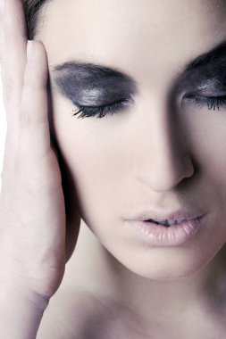 Makyajlı bir kadının yüzüne yakın çekim.