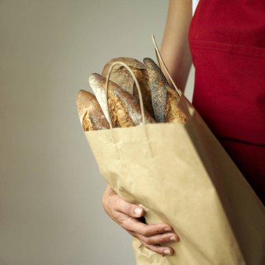 Elinde ekmek torbası tutan bir kadın.