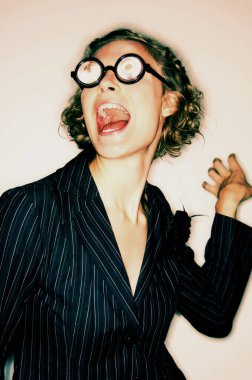 Güneş gözlüğü takmış resmi giyinmiş bir kadın çığlık atıyor.