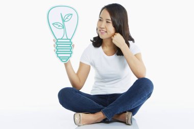 Woman holding up a light bulb made of cardboard clipart