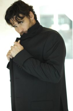 Ağzını paltosuyla kapatan bir adamın yan görüntüsü.