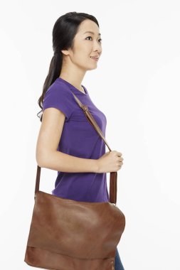 Kahverengi askı çantası taşıyan kadın.