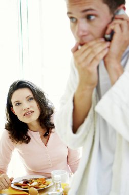 Karısı gibi cep telefonunda fısıldayan bir adam şüpheli bir şekilde izliyor.