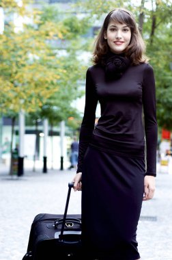 Bir kadın bavulunu çekiyor.