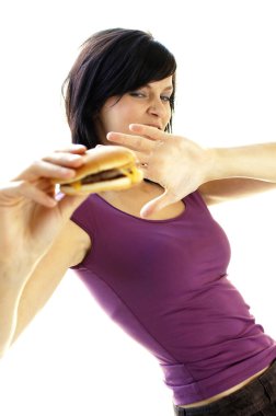 Bir kadın peynirli burger yemekten kaçınıyor.