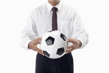 Futbol menajeri elinde top tutuyor.