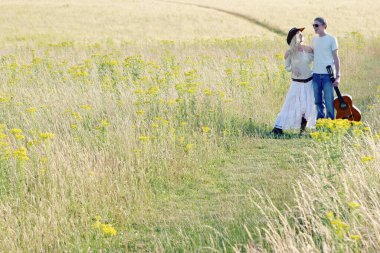 Çayırda birlikte yürüyen bir çift.