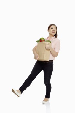 Woman carrying a bag of groceries clipart