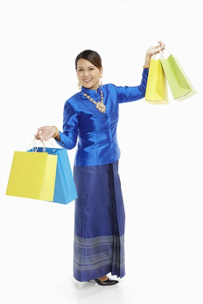 紙袋を持っている伝統的な服の中で陽気な女性 — ストック写真
