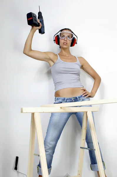Una Mujer Con Gafas Auriculares Levantando Taladro Por Encima Cabeza — Foto de Stock