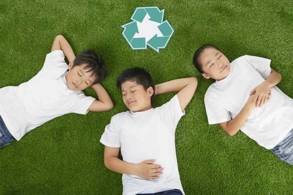 Drie Kinderen Liggend Het Gras Met Gesloten Ogen — Stockfoto