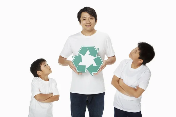 Vader Houdt Een Recycle Logo Terwijl Zonen Kijken — Stockfoto
