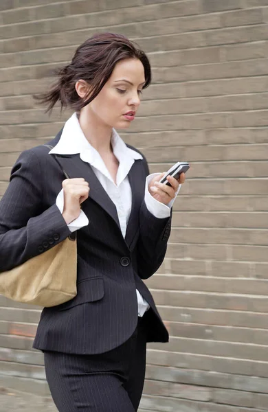 仕事に歩いている間に忙しいビジネス女性のテキストメッセージ — ストック写真