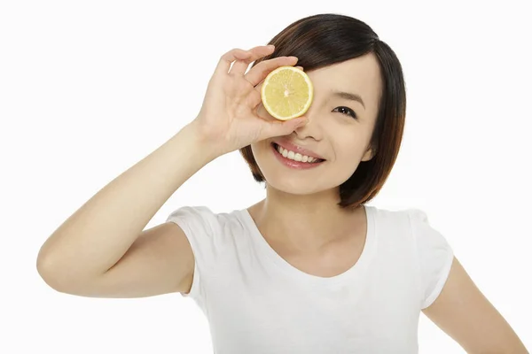 Fröhliche Frau Bedeckt Ihr Auge Mit Einer Zitrone — Stockfoto