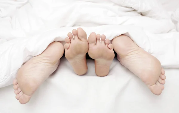 close up of Couple feet in bed
