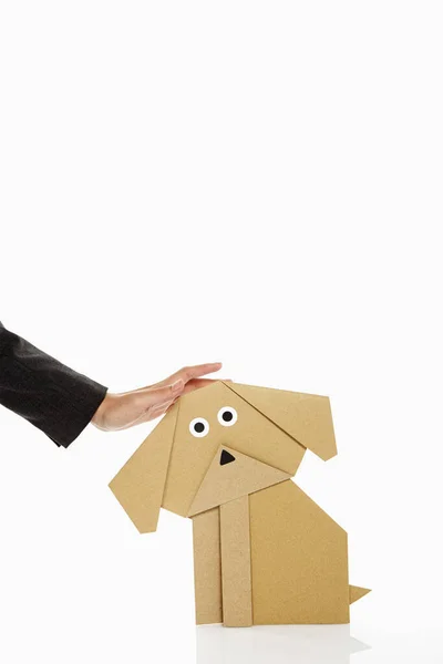 Menschliche Hand Streichelt Einen Papierhund — Stockfoto