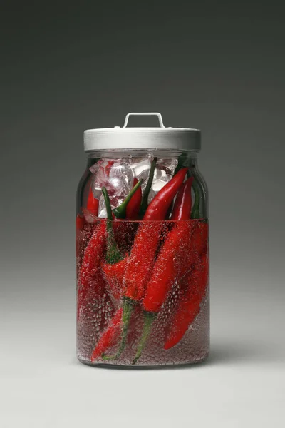 Red chillies in a jar of ice cubes