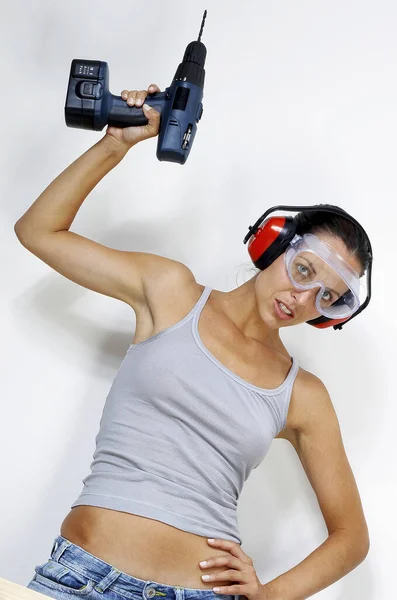 Una Mujer Con Gafas Auriculares Levantando Taladro Por Encima Cabeza — Foto de Stock