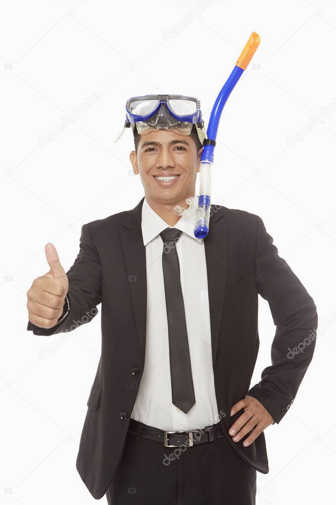 Businessman with swimming gear giving thumbs up