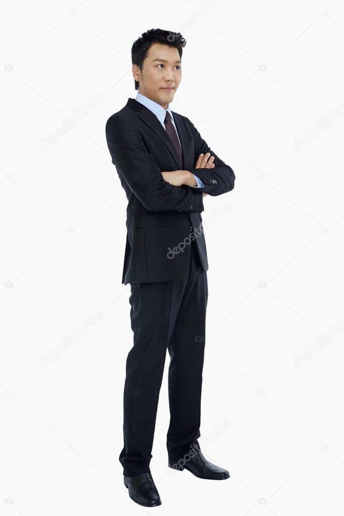 Cheerful businessman standing with arms crossed