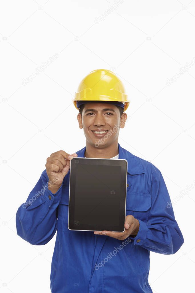 Construction worker holding up a digital tablet
