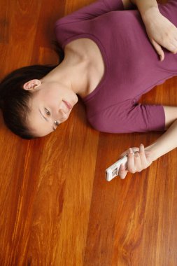 Yerde yatan kadın cep telefonundan mesaj atıyor.