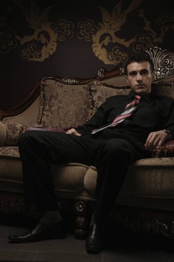 Antika koltukta oturan bir iş adamı.