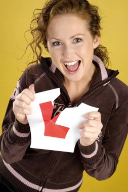 Kadın L çıkartmasını yırtıyor.