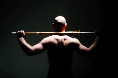 Kılıç tutan üstsüz adamın arka planı.