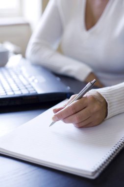 Not defterine yazmak üzere olan kadın.