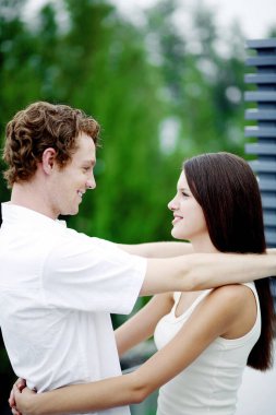 Birbirlerine sarılırken gülümseyen çiftler.