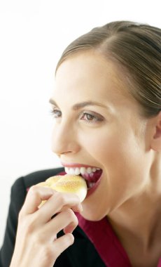 İş kadını çöreği ısırıyor.