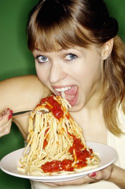 Genç kadın spagetti yiyor.