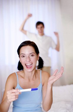 Hamilelik testinin sonucuna baktıktan sonra sevinen bir çift.